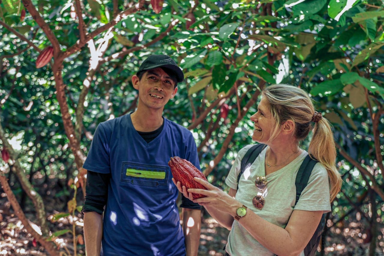 Photo d'un producteur de fèves de cacao souriant avec Rose Marie souriante aussi