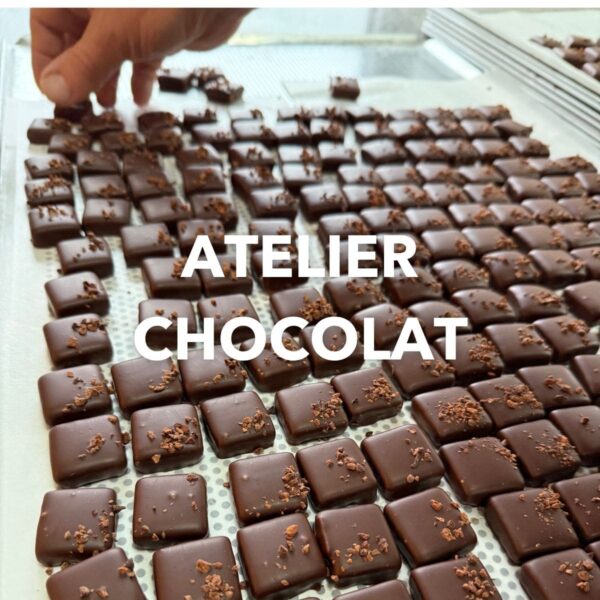 Photo de praliné noisette avec une main, inscription atelier chocolat